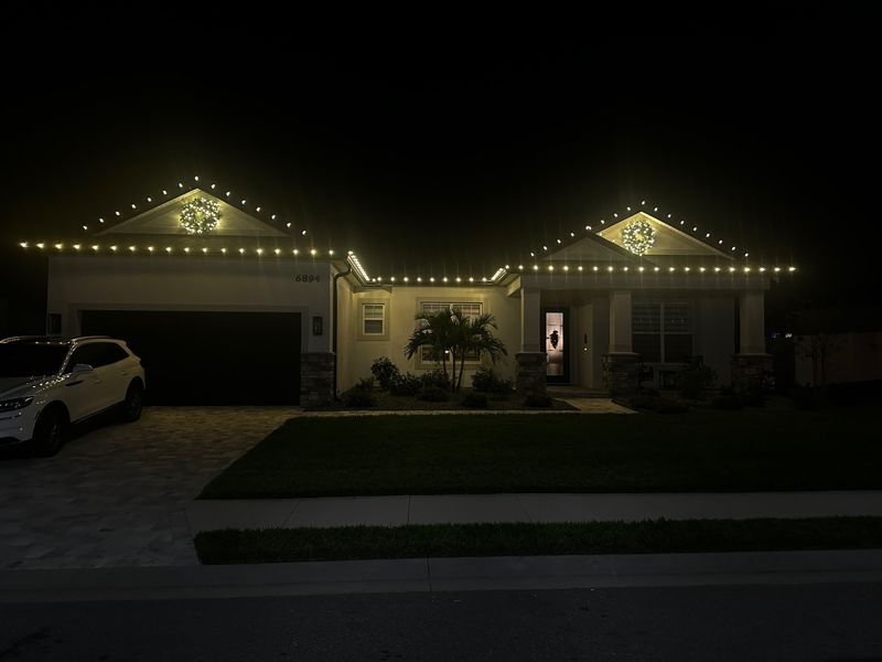 Florida home with C9 roofline Christmas lights above the garage and front entry